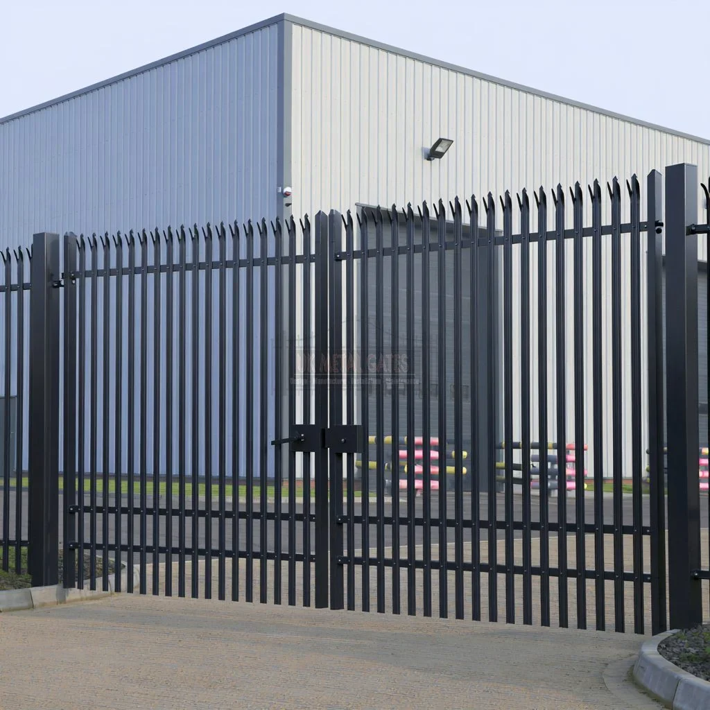 Home 80 Black palisade double gates outside a light grey industrial building.
